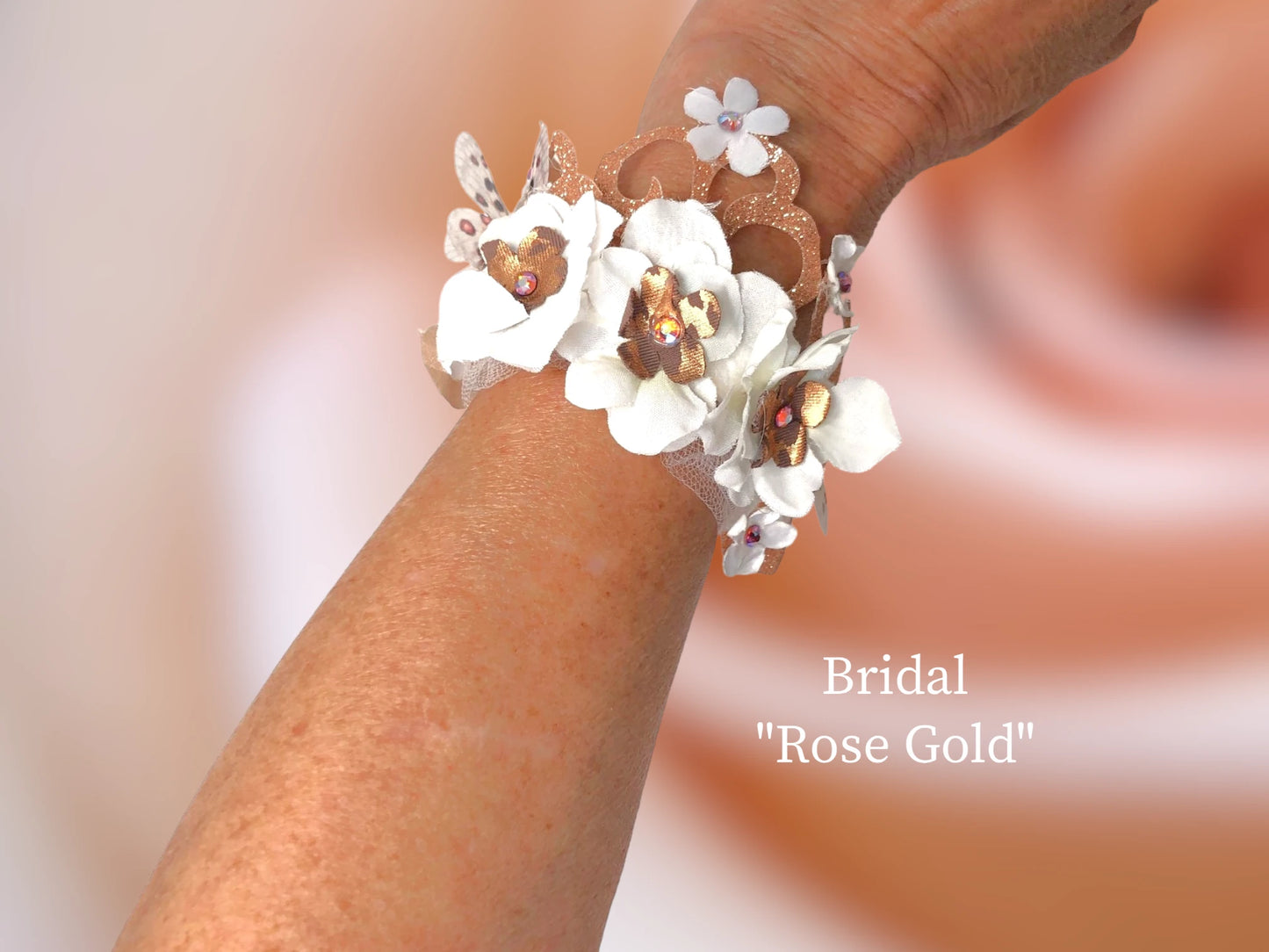 Rose Gold themed w/ satin silk flowers w/ rose gold center w/ Topaz Austrian Crystal, Rose gold sparkle scroll lace, rose gold and white silk flowers w/ Austrian Crystal centers, and 2 delicate 3-D chiffon butterflies adorn this lovely Bridal bracelet. $45.99