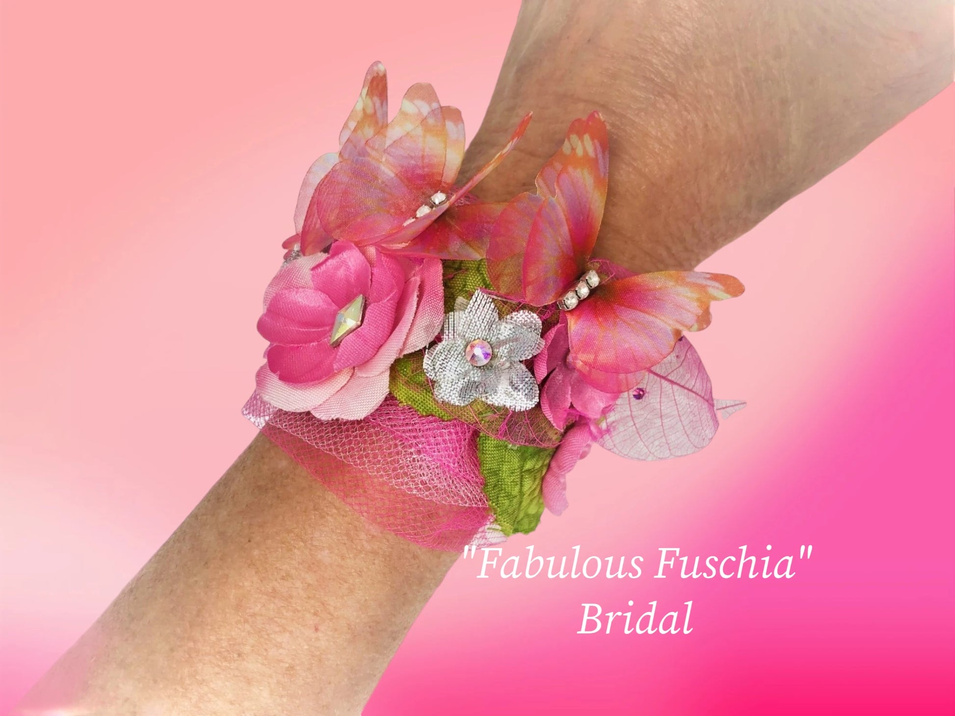 Fabulous Fuschia- Bride's Maids faux suede light weight magnetic bracelet with silk and silver lame' flowers and Austrian crystal centers. Delicate Fuschia tulle, silk green leaf, adorable fuschia chiffon 3-D butterflies with rhinestone center, delicate and filmy fuschia skeleton leaves and tiny crystal dew drops make this bracelet a beautiful arm piece for the bridal crew! $46.99