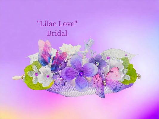 Lilac Love - lightweight w/ magnetic closure. Lilac, white & white silk flowers with Austrian Crystal centers, baby's breath, silver lame' and green silk leaves, silver skeleton leaves with crystal dew drops, purple butterfly with rhinestone center, and lilac tulle make up this beautiful arm piece. $46.99