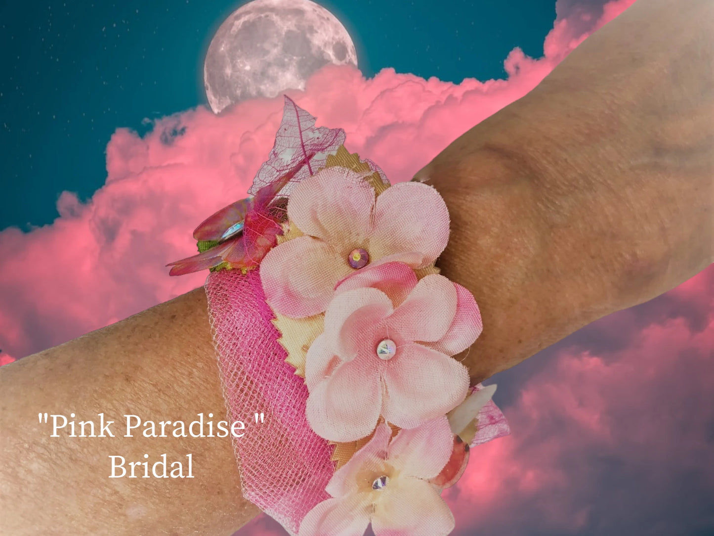 Pink Paradise- lightweight magnetic closure, pink silk flowers with crystal centers Ivory and green silk leaves, 2 chiffon butterflies w/ crystal center, pink skeleton leaves w/ crystal dew drops, delicate tulle, make up this beautiful arm piece. $44.99